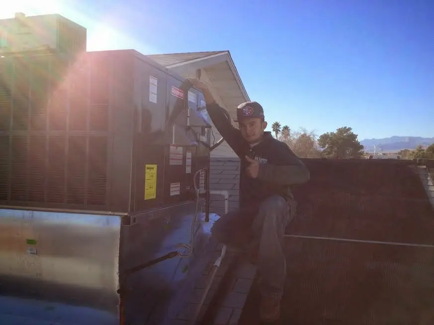 HVAC technician performing AC Tune-Up on a rooftop unit in Fullerton